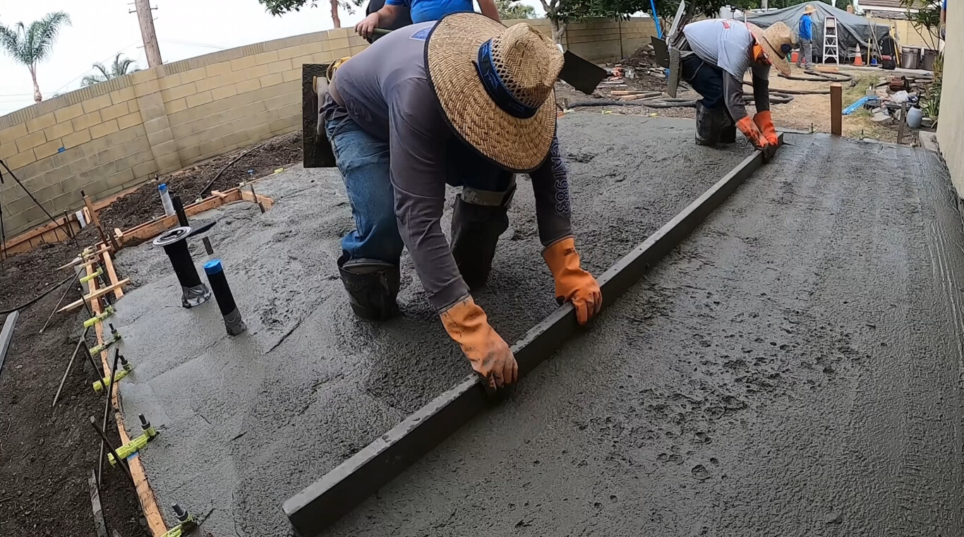 Professional concrete worker finishing a driveway installation in Pittsburg, CA